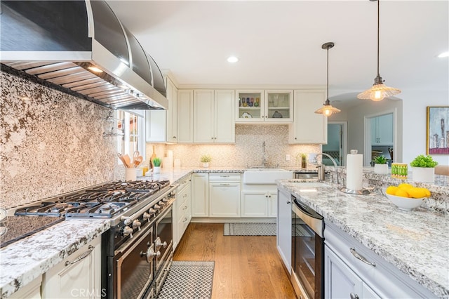 4022 Willowcrest Ave, Studio City, CA 91604 - kitchen with exhaust hood, light wood-type flooring, light stone counters, hanging light fixtures, and decorative backsplash