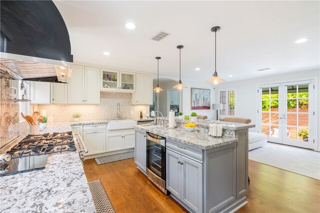 4022 Willowcrest Ave, Studio City, CA 91604 - kitchen with ventilation hood, beverage cooler, light wood-style flooring, tasteful backsplash, and glass insert cabinets