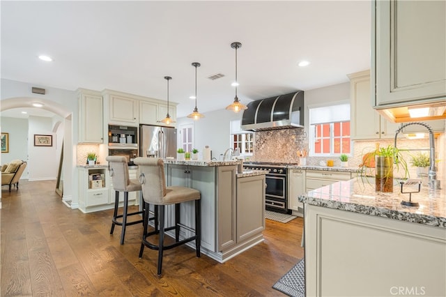 4022 Willowcrest Ave, Studio City, CA 91604 - kitchen with wall chimney range hood, range with gas stovetop, backsplash, arched walkways, and light stone countertops