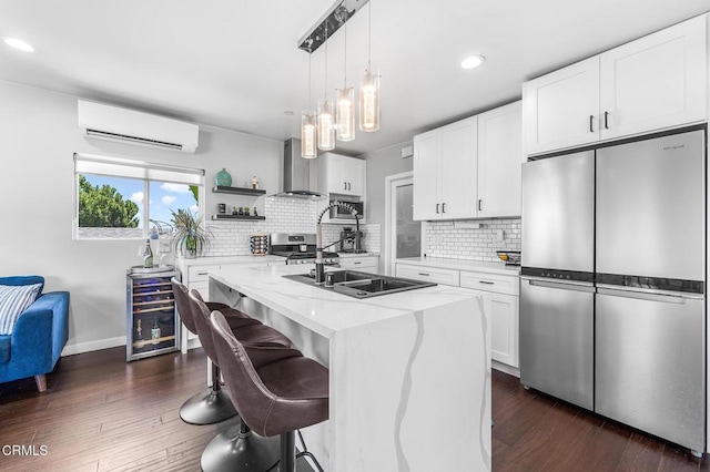 4255 Raynol St, Los Angeles, CA 90032 - kitchen with appliances with stainless steel finishes, a wall mounted air conditioner, wall chimney range hood, light stone countertops, and recessed lighting