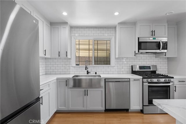 17172 Lahey St, Granada Hills, CA 91344 - kitchen with stainless steel appliances, decorative backsplash, light wood-style floors, light stone counters, and recessed lighting