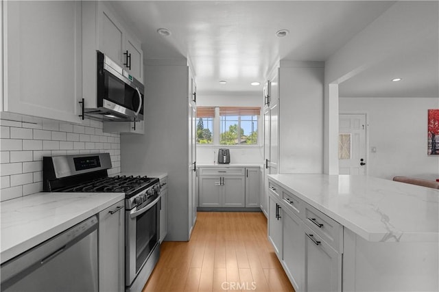17172 Lahey St, Granada Hills, CA 91344 - kitchen with stainless steel appliances, backsplash, light stone counters, light wood-style flooring, and recessed lighting
