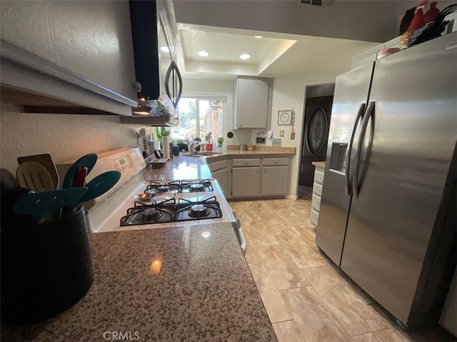 6720 Shaded Wood Pl, Rancho Cucamonga, CA 91701 - kitchen featuring stainless steel appliances, a tray ceiling, recessed lighting, washer / clothes dryer, and white cabinetry