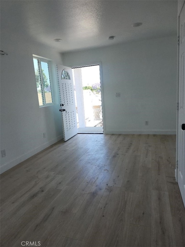 10531 Alexander Ave, South Gate, CA 90280 - spare room featuring plenty of natural light, wood finished floors, and a textured ceiling