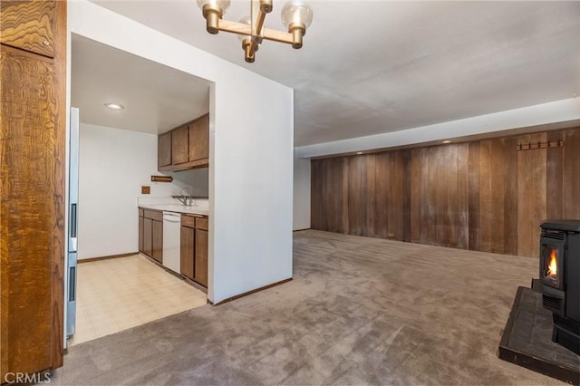 2113 Meridian Blvd Unit 133, Mammoth Lakes, CA 93546 - unfurnished living room featuring a wood stove, a chandelier, light carpet, and wooden walls