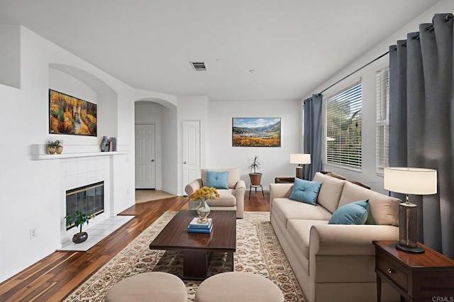 6410 Terraza Portico, Carlsbad, CA 92009 - living area with wood finished floors, a tile fireplace, and arched walkways
