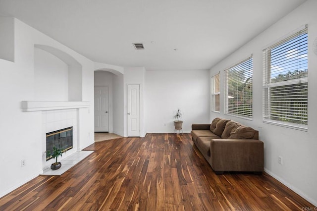 6410 Terraza Portico, Carlsbad, CA 92009 - living area with wood finished floors, a tiled fireplace, and arched walkways