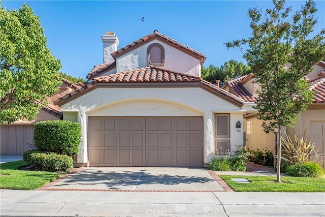 5620 La Paz St, Long Beach, CA 90803 - mediterranean / spanish-style house with concrete driveway, an attached garage, stucco siding, a tile roof, and a chimney