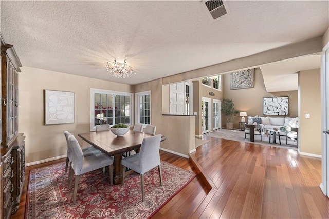 5620 La Paz St, Long Beach, CA 90803 - dining area with a chandelier, a textured ceiling, and hardwood / wood-style floors
