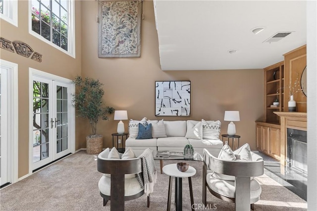5620 La Paz St, Long Beach, CA 90803 - living area featuring french doors, a high ceiling, a high end fireplace, and carpet flooring