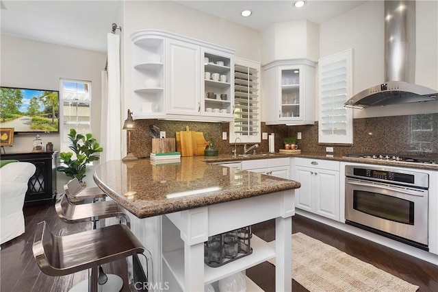 6 Via Amanti, Newport Coast, CA 92657 - kitchen featuring appliances with stainless steel finishes, wall chimney exhaust hood, open shelves, a peninsula, and dark stone counters