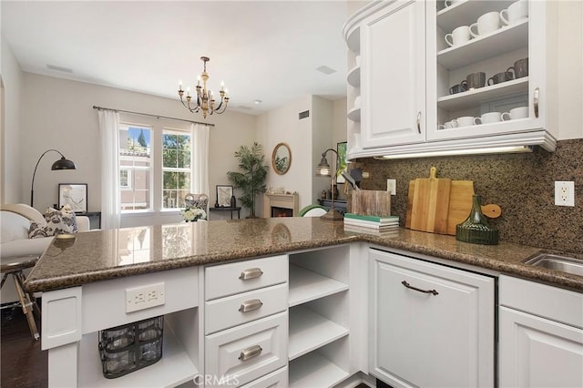 6 Via Amanti, Newport Coast, CA 92657 - kitchen featuring open shelves, a chandelier, decorative backsplash, white cabinets, and dark stone countertops