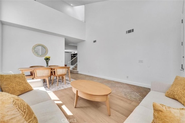 7059 E Monaco, Orange, CA 92867 - living room with stairs, a high ceiling, and light wood-type flooring