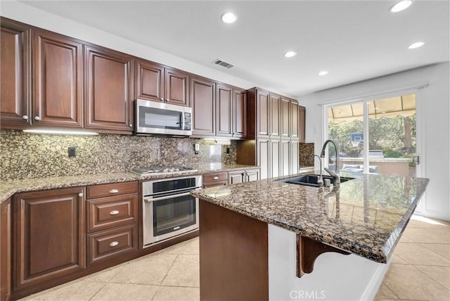 7059 E Monaco, Orange, CA 92867 - kitchen featuring appliances with stainless steel finishes, light tile patterned floors, recessed lighting, dark stone counters, and backsplash
