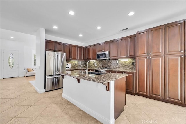 7059 E Monaco, Orange, CA 92867 - kitchen featuring stainless steel appliances, stone counters, a breakfast bar area, tasteful backsplash, and light tile patterned floors