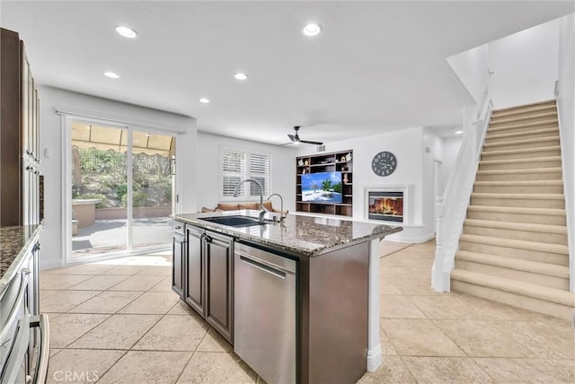7059 E Monaco, Orange, CA 92867 - kitchen with stainless steel dishwasher, a glass covered fireplace, a ceiling fan, recessed lighting, and dark stone counters