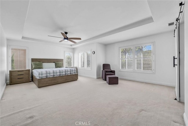 7059 E Monaco, Orange, CA 92867 - carpeted bedroom featuring a tray ceiling, a barn door, multiple windows, and a ceiling fan