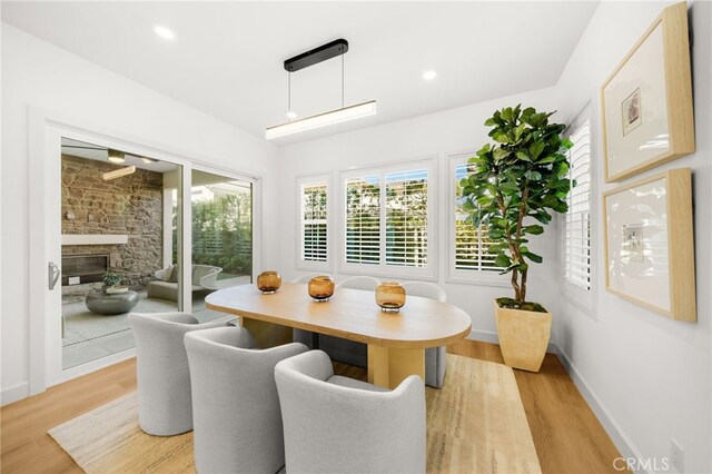 56 Cartwheel, Irvine, CA 92618 - dining room featuring light wood finished floors and a stone fireplace