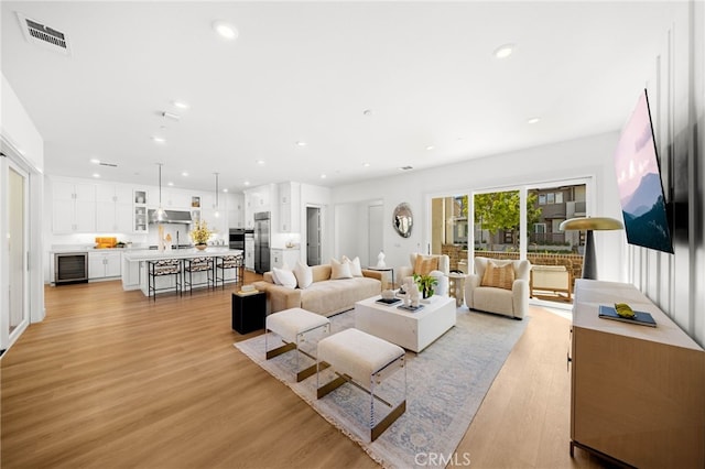 56 Cartwheel, Irvine, CA 92618 - living area featuring wine cooler, light wood-type flooring, and recessed lighting
