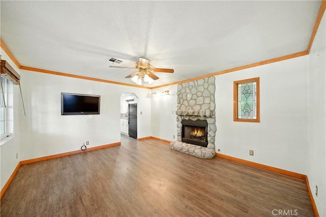 1125 Indian Springs Dr, Glendora, CA 91741 - unfurnished living room featuring wood finished floors, a fireplace, ceiling fan, crown molding, and arched walkways