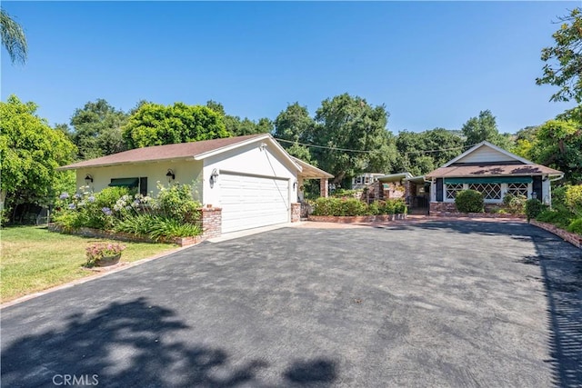 1125 Indian Springs Dr, Glendora, CA 91741 - view of front facade featuring asphalt driveway, a garage, stucco siding, a front lawn, and view of wooded area