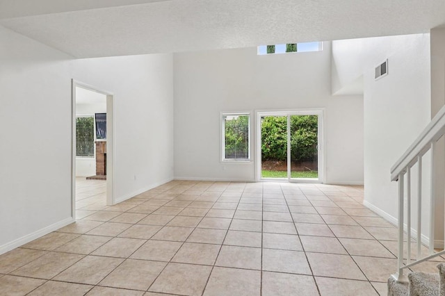 10559 Lansford Ln, San Diego, CA 92126 - unfurnished living room with light tile patterned floors, stairs, and a textured ceiling