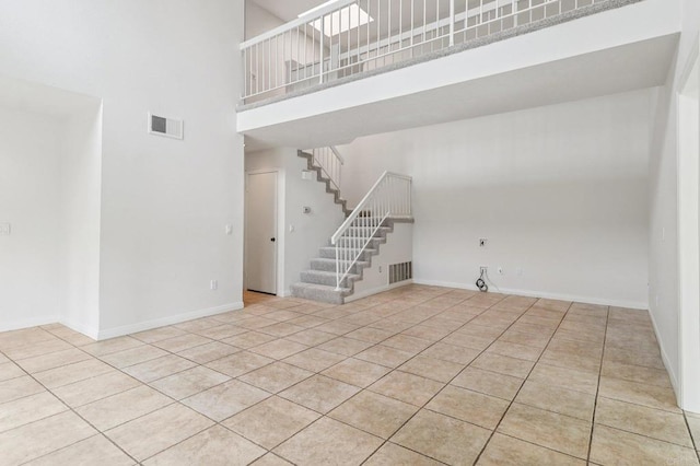10559 Lansford Ln, San Diego, CA 92126 - unfurnished living room featuring a towering ceiling, tile patterned floors, and stairway