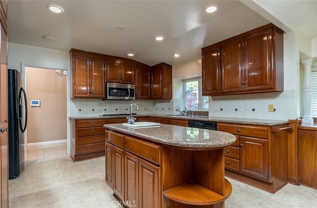 1835 Las Flores Dr, Glendale, CA 91207 - kitchen with black appliances, stone countertops, backsplash, open shelves, and an island with sink