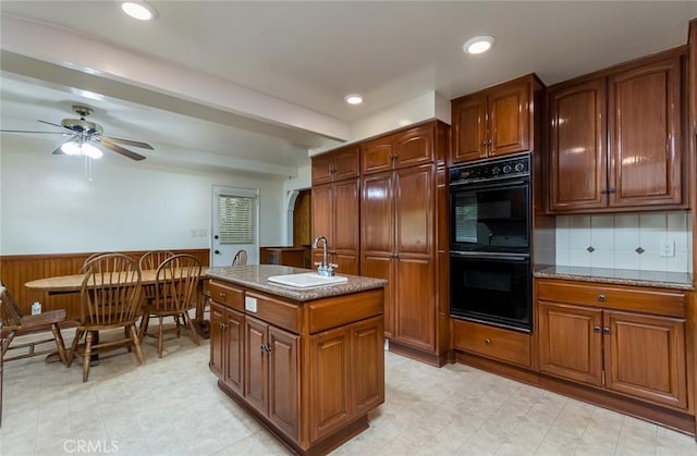 1835 Las Flores Dr, Glendale, CA 91207 - kitchen featuring a wainscoted wall, a kitchen island with sink, a ceiling fan, brown cabinetry, and recessed lighting