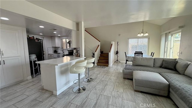 681 N Lark Ellen Ave, Covina, CA 91722 - living room featuring a chandelier, stairs, plenty of natural light, recessed lighting, and vaulted ceiling