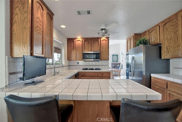 18032 Ohna Rd, Apple Valley, CA 92307 - kitchen featuring stainless steel appliances, tasteful backsplash, tile countertops, ceiling fan, and recessed lighting
