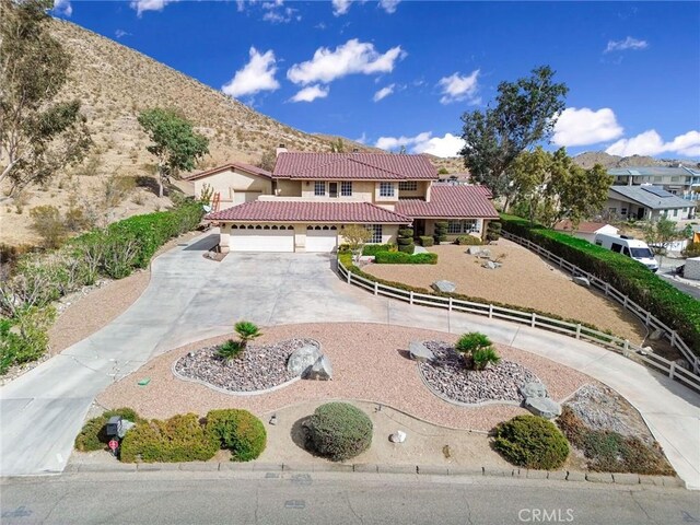 18032 Ohna Rd, Apple Valley, CA 92307 - mediterranean / spanish home featuring a tiled roof, curved driveway, stucco siding, and a mountain view