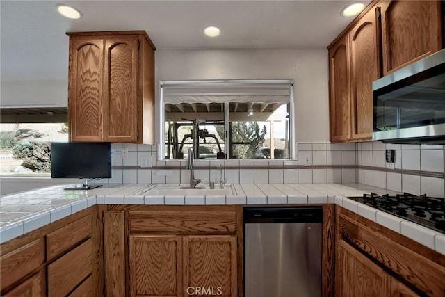 18032 Ohna Rd, Apple Valley, CA 92307 - kitchen with appliances with stainless steel finishes, tasteful backsplash, brown cabinetry, and recessed lighting