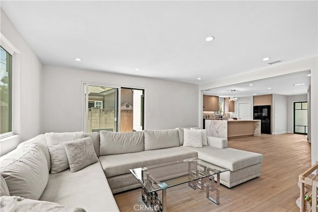 6832 Cantaloupe Ave, Van Nuys, CA 91405 - living area featuring healthy amount of natural light, light wood finished floors, and recessed lighting