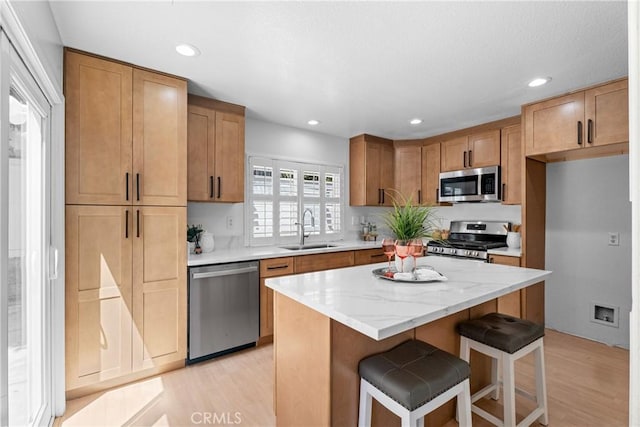 2 Chestnut Dr, Aliso Viejo, CA 92656 - kitchen with appliances with stainless steel finishes, light wood-style flooring, a kitchen island, a kitchen bar, and recessed lighting