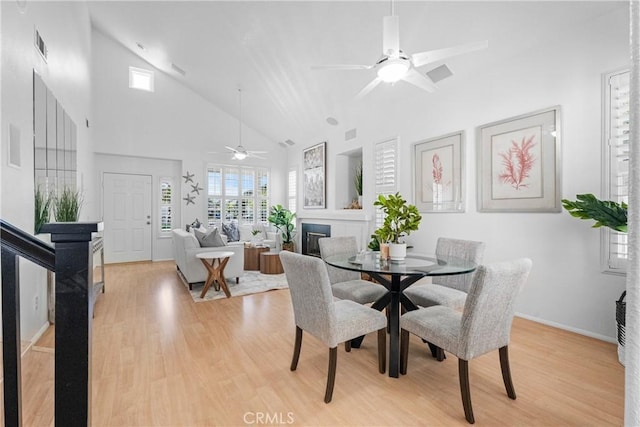 2 Chestnut Dr, Aliso Viejo, CA 92656 - dining space featuring high vaulted ceiling, ceiling fan, light wood-style floors, and a glass covered fireplace