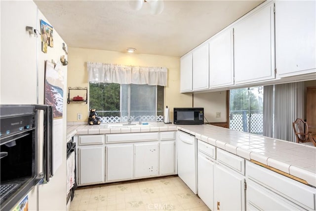 27786 Matterhorn Dr, Lake Arrowhead, CA 92352 - kitchen with black appliances, white cabinets, and light floors