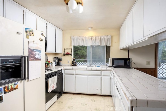 27786 Matterhorn Dr, Lake Arrowhead, CA 92352 - kitchen featuring white fridge with ice dispenser, black microwave, tile countertops, gas stove, and white cabinets