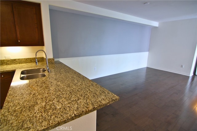 629 Traction Ave Unit 508, Los Angeles, CA 90013 - kitchen with light stone countertops, dark wood finished floors, a wainscoted wall, and a peninsula
