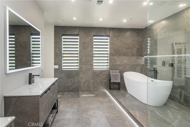 18824 Juniper Springs Dr, Canyon Country, CA 91321 - full bath featuring vanity, a soaking tub, marble tiled floors, tile walls, and a walk in shower