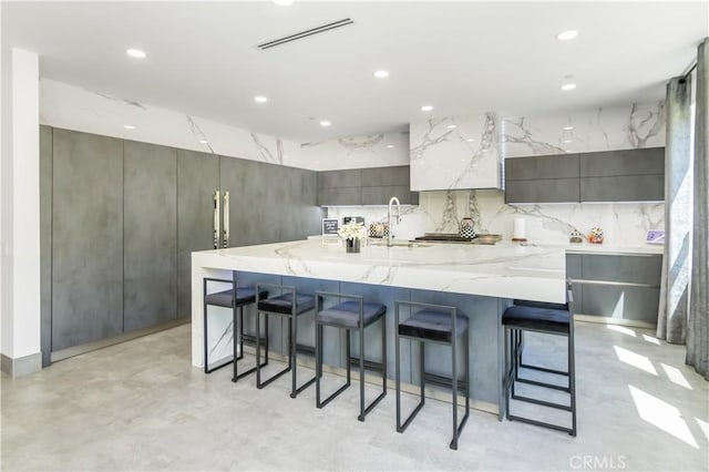 18824 Juniper Springs Dr, Canyon Country, CA 91321 - kitchen with modern cabinets, recessed lighting, a breakfast bar area, a spacious island, and light stone counters