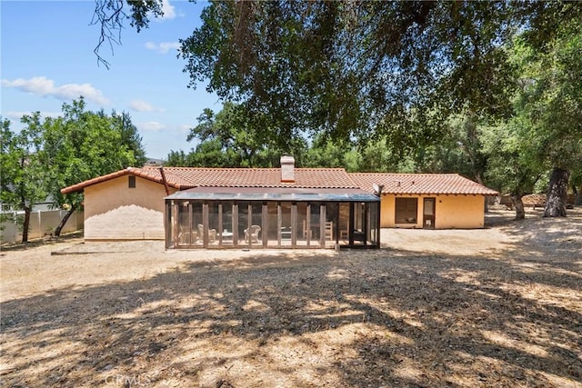 31039 Hasley Canyon Rd, Castaic, CA 91384 - back of house with a sunroom, a tile roof, a chimney, and stucco siding