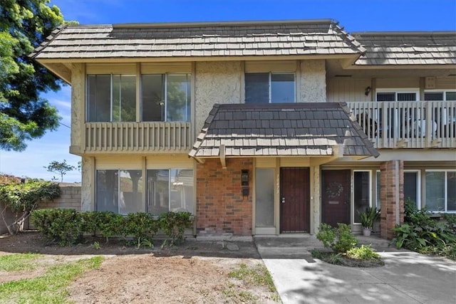10473 Smoke River Ct, Fountain Valley, CA 92708 - view of front facade with brick siding, mansard roof, and a balcony