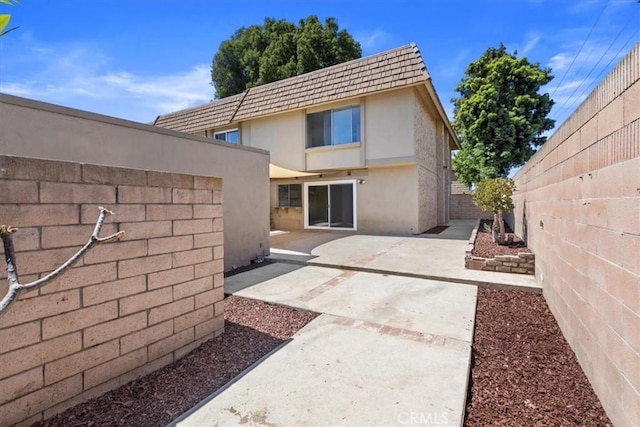 10473 Smoke River Ct, Fountain Valley, CA 92708 - back of house featuring stucco siding, mansard roof, a patio, and a fenced backyard
