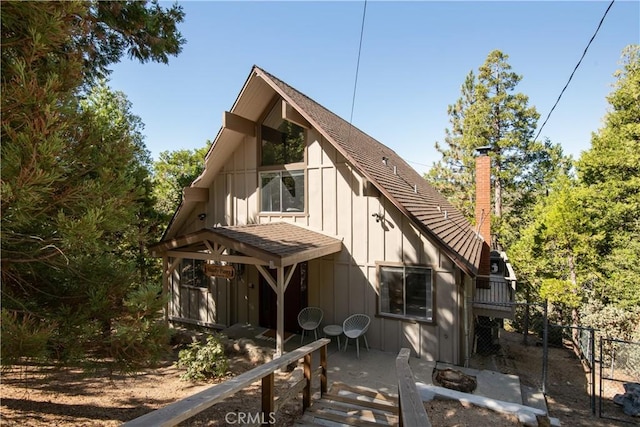 832 Rhine Rd, Lake Arrowhead, CA 92352 - rear view of house with a chimney, board and batten siding, and a wooden deck