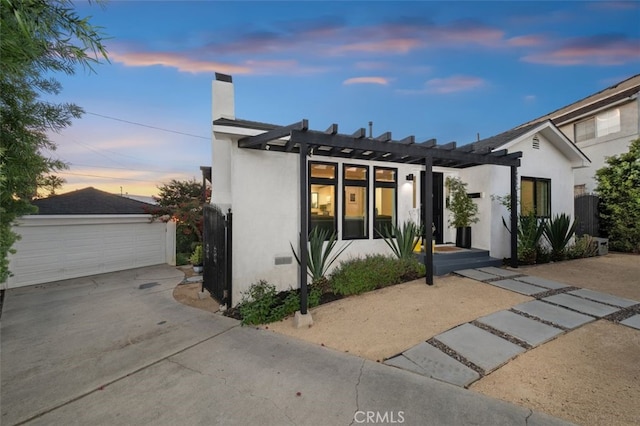 2329 Vineyard Ave, Los Angeles, CA 90016 - view of front of property featuring stucco siding, an outbuilding, a pergola, a chimney, and a garage