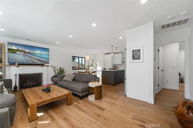 2329 Vineyard Ave, Los Angeles, CA 90016 - living room featuring light wood-style flooring, recessed lighting, and a fireplace