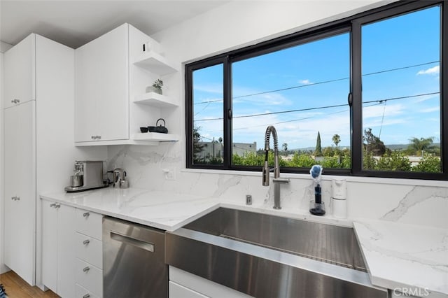 2329 Vineyard Ave, Los Angeles, CA 90016 - kitchen with stainless steel dishwasher, open shelves, healthy amount of natural light, and light stone countertops