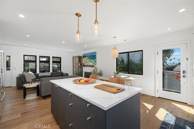 2329 Vineyard Ave, Los Angeles, CA 90016 - kitchen featuring recessed lighting, light wood-style flooring, a center island, hanging light fixtures, and dark cabinetry