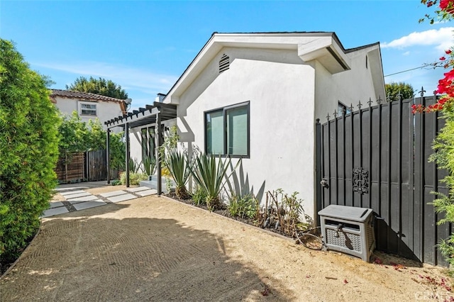 2329 Vineyard Ave, Los Angeles, CA 90016 - view of front of house featuring a pergola, stucco siding, a patio area, and a gate